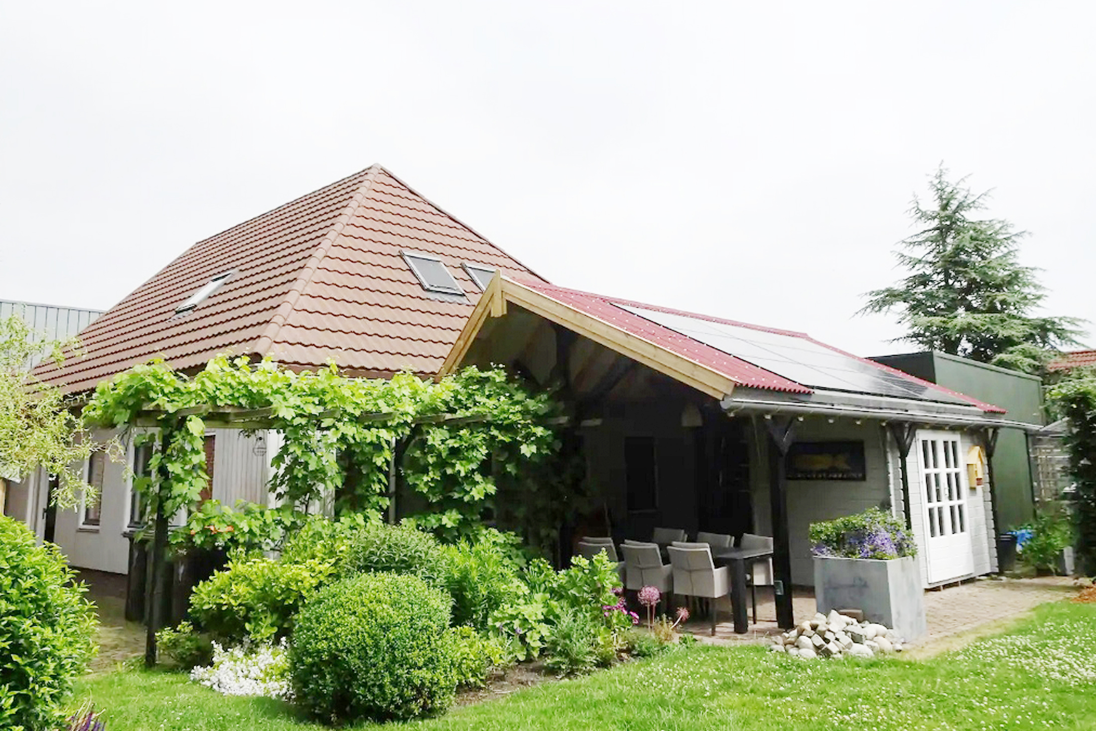 De tuin met het overkapte terras